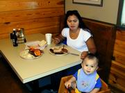 Adult and Child Eating at Restaurant Booth